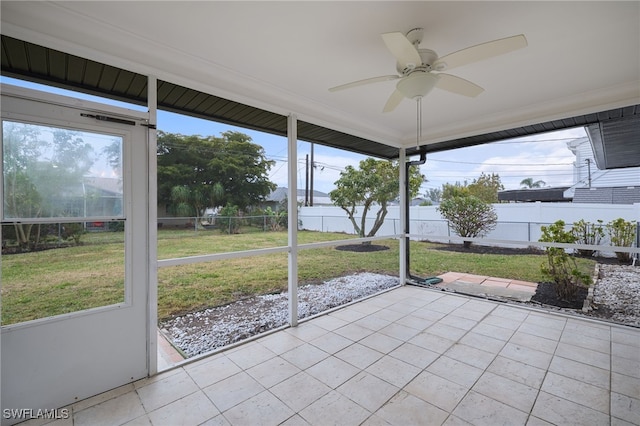 unfurnished sunroom featuring ceiling fan