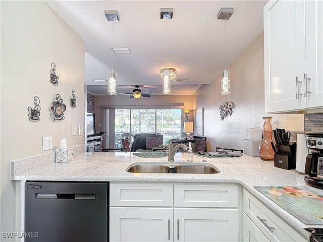 kitchen featuring black dishwasher, sink, white cabinets, hanging light fixtures, and light stone countertops