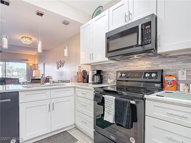 kitchen featuring sink, white cabinetry, hanging light fixtures, stainless steel appliances, and backsplash