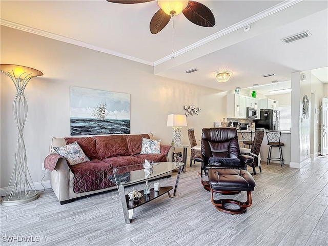 living room with crown molding and ceiling fan