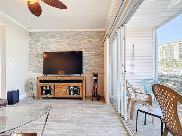 living room featuring ornamental molding, light wood-type flooring, and ceiling fan