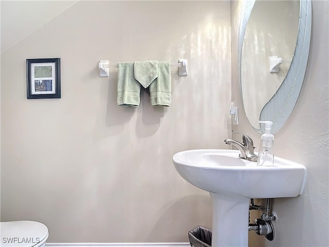 bathroom with vaulted ceiling and toilet