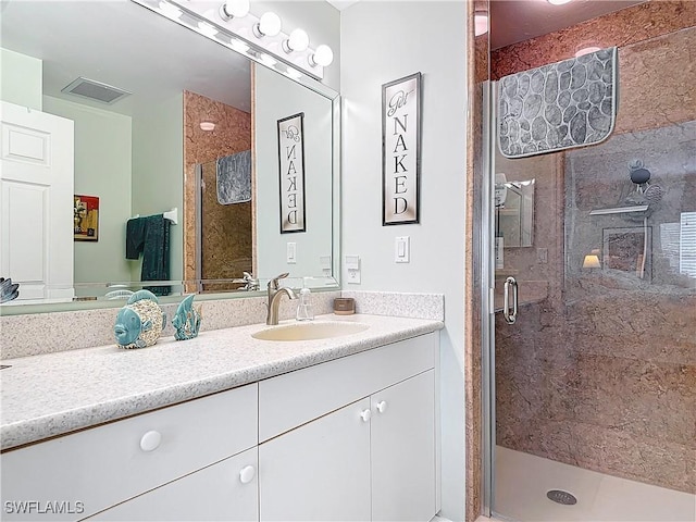 bathroom featuring vanity and a shower with door