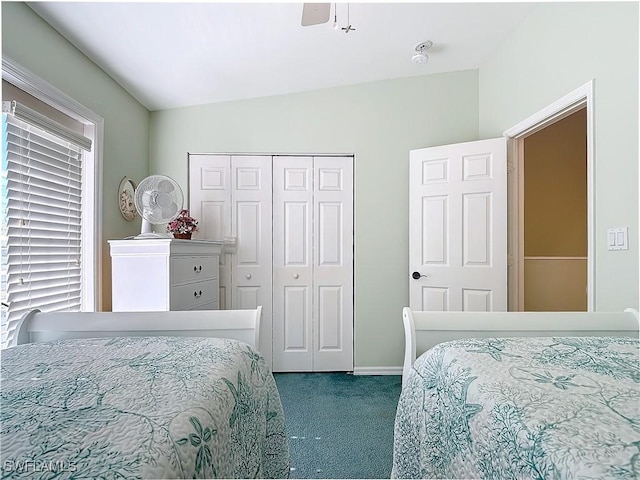 carpeted bedroom featuring ceiling fan, lofted ceiling, and a closet