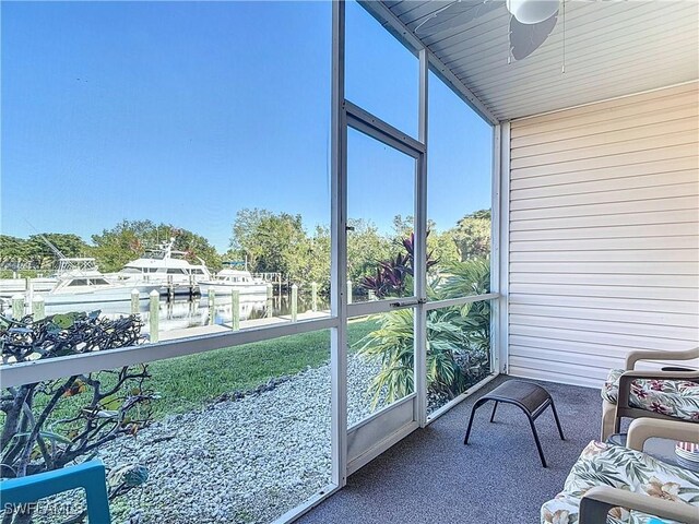 sunroom featuring a water view