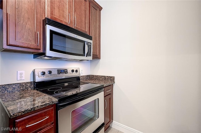 kitchen featuring stainless steel appliances and dark stone counters