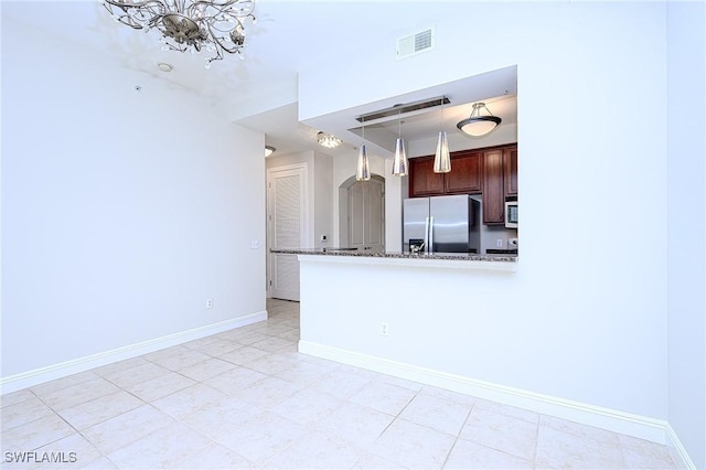 kitchen with stainless steel appliances, stone countertops, hanging light fixtures, kitchen peninsula, and light tile patterned floors