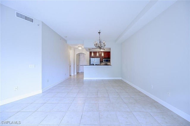 unfurnished living room with a chandelier and light tile patterned flooring