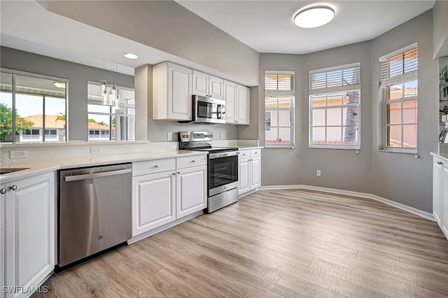 kitchen featuring light hardwood / wood-style flooring, stainless steel appliances, and white cabinets