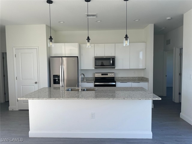 kitchen featuring stainless steel appliances, white cabinetry, and a center island with sink