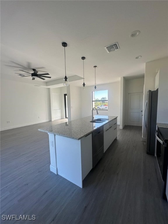 kitchen featuring appliances with stainless steel finishes, sink, decorative light fixtures, white cabinetry, and a center island with sink