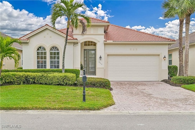 mediterranean / spanish-style home featuring a front yard and a garage