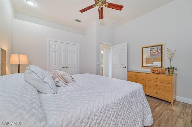 bedroom with ceiling fan, light hardwood / wood-style floors, and a closet