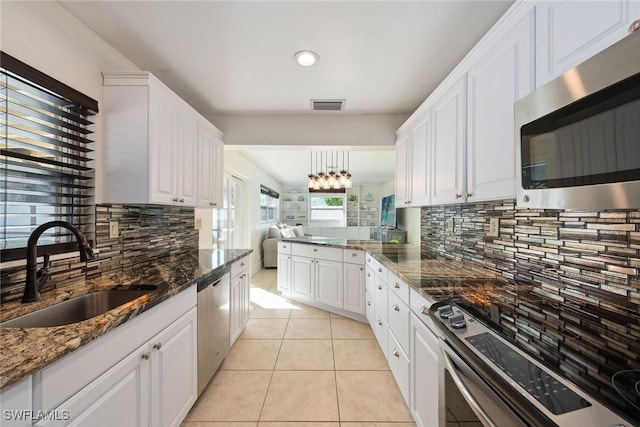 kitchen with white cabinetry, sink, light tile patterned floors, and stainless steel appliances