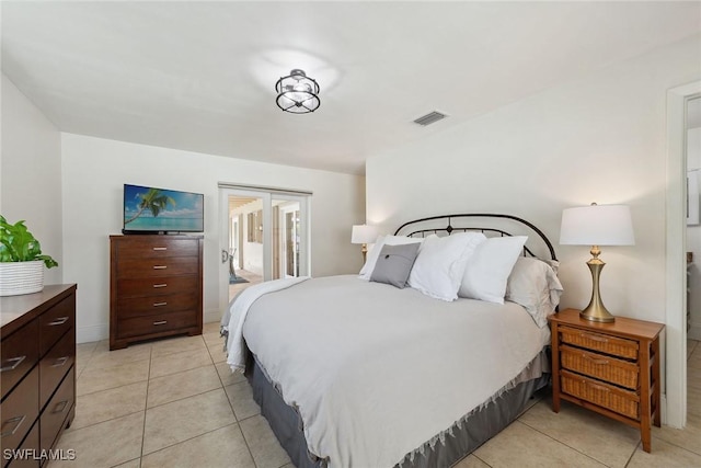 bedroom with connected bathroom and light tile patterned flooring