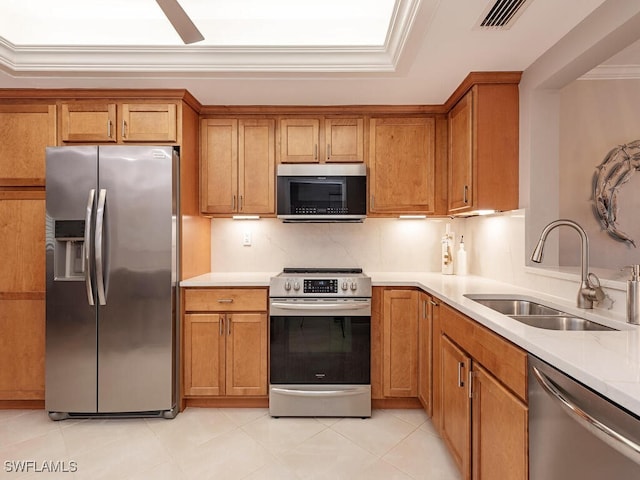 kitchen featuring appliances with stainless steel finishes, a sink, and brown cabinets