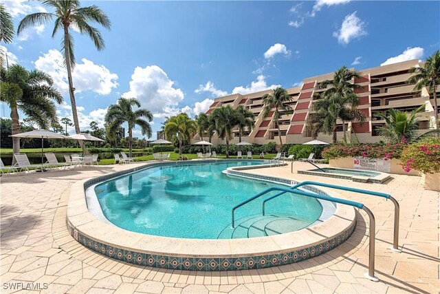 view of swimming pool with a patio area and a hot tub