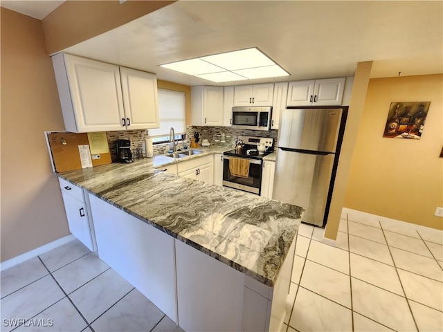 kitchen with white cabinets, appliances with stainless steel finishes, sink, and stone counters