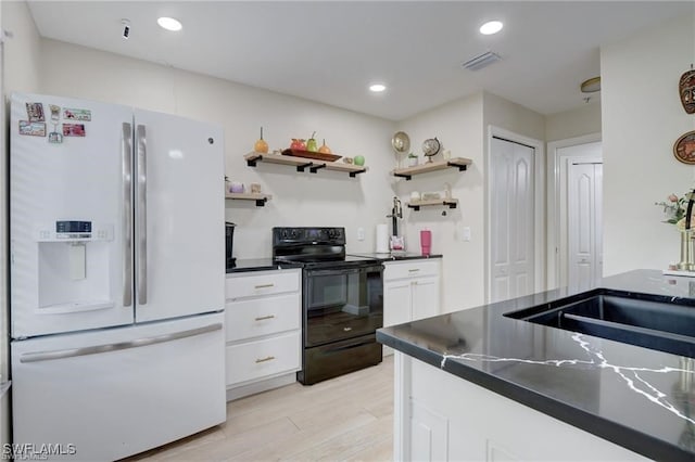 kitchen with light hardwood / wood-style floors, white fridge with ice dispenser, white cabinets, sink, and electric range