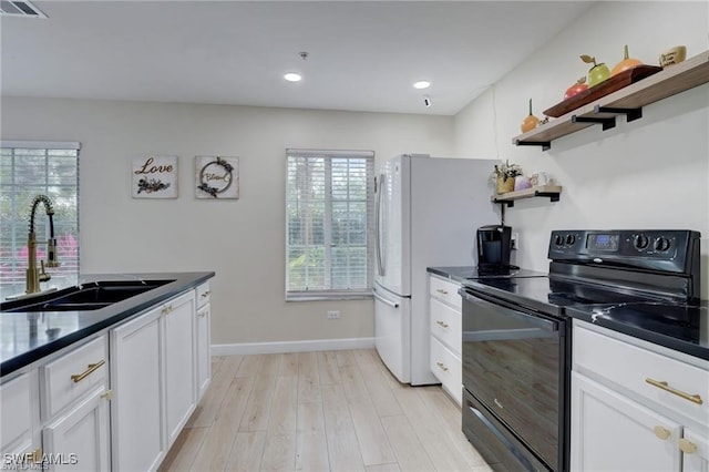 kitchen with light hardwood / wood-style floors, sink, white cabinets, and black range with electric stovetop