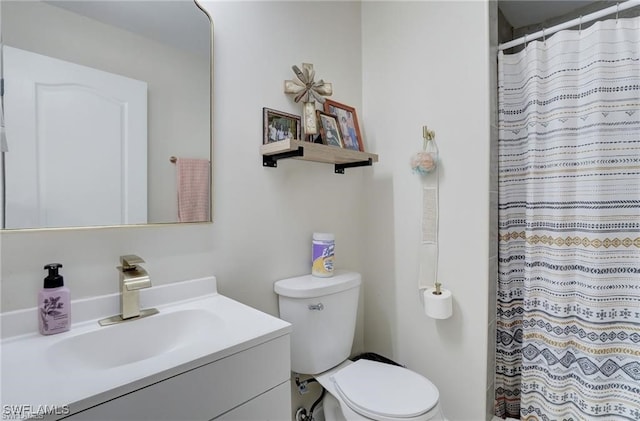 bathroom featuring toilet, vanity, and walk in shower