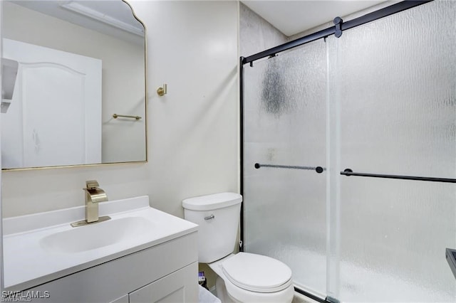 bathroom with an enclosed shower, vanity, and toilet