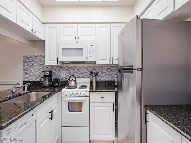 kitchen featuring white cabinetry, sink, white appliances, and dark stone counters