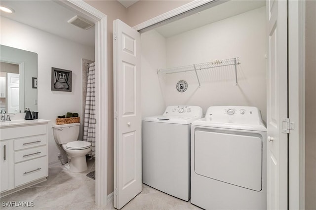 laundry room with sink, light tile patterned floors, and washing machine and clothes dryer