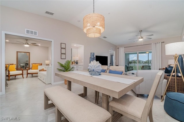 dining area featuring light tile patterned floors, ceiling fan with notable chandelier, and vaulted ceiling