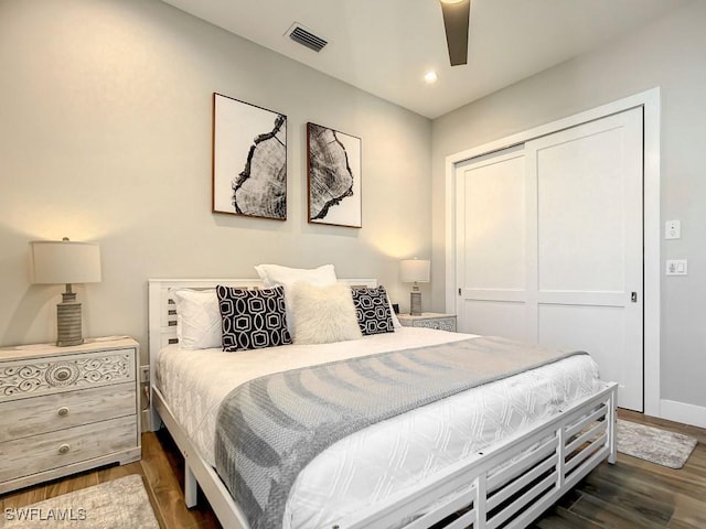 bedroom with ceiling fan, dark hardwood / wood-style flooring, and a closet