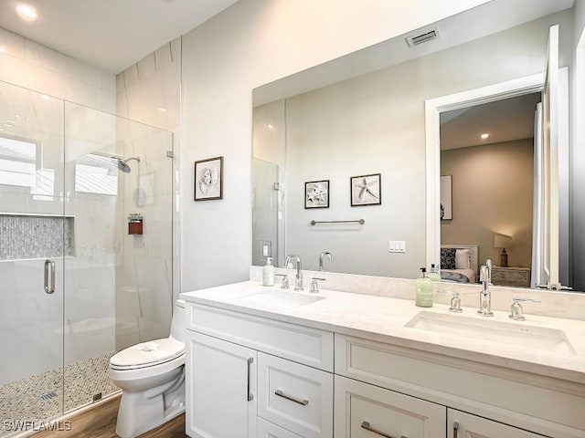 bathroom featuring vanity, toilet, and a shower with door