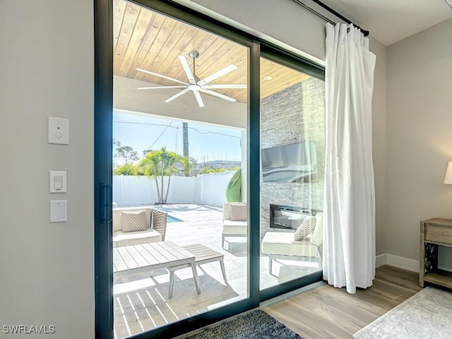 doorway with hardwood / wood-style flooring and ceiling fan