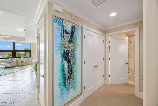 hallway featuring ornamental molding and light tile patterned floors