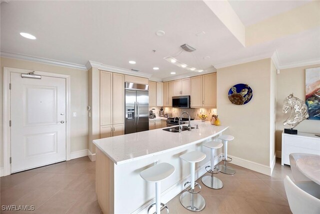 kitchen with a kitchen bar, sink, crown molding, kitchen peninsula, and stainless steel appliances