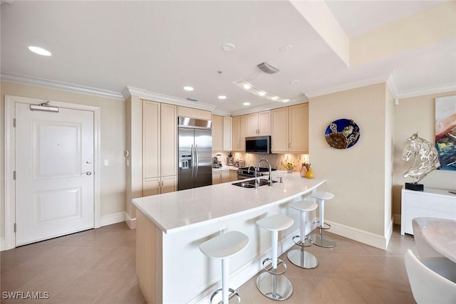 kitchen with a breakfast bar area, stainless steel appliances, ornamental molding, sink, and kitchen peninsula