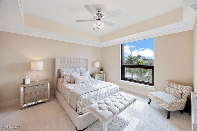 bedroom with ceiling fan, light colored carpet, ornamental molding, and a raised ceiling