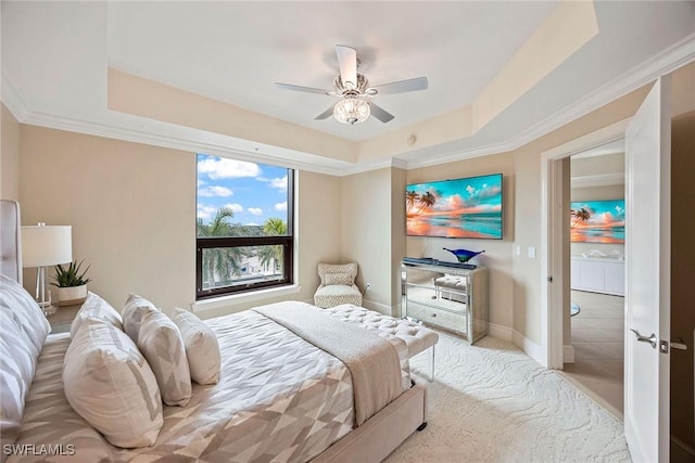 bedroom with ceiling fan, a tray ceiling, and ornamental molding