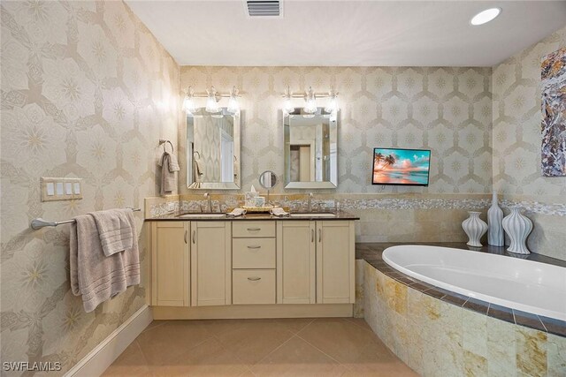 bathroom with vanity, a relaxing tiled tub, and tile patterned floors