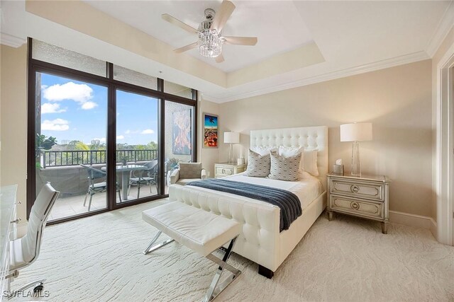 carpeted bedroom featuring crown molding, access to exterior, a tray ceiling, and ceiling fan