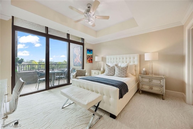 carpeted bedroom featuring a tray ceiling, crown molding, access to outside, and ceiling fan