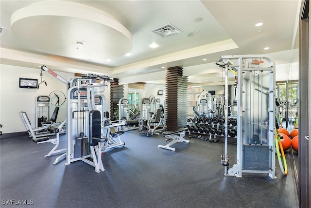 workout area with a tray ceiling