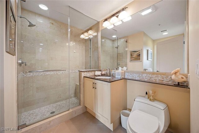 bathroom with vanity, toilet, tile patterned flooring, and a shower with door