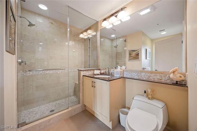 bathroom with tile patterned flooring, toilet, vanity, and walk in shower