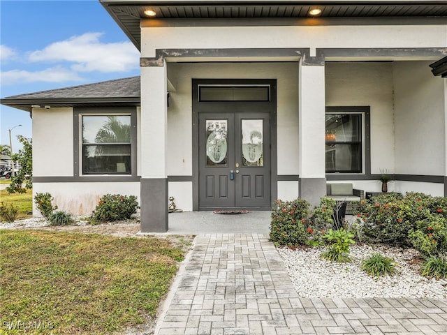 property entrance featuring a porch and a lawn