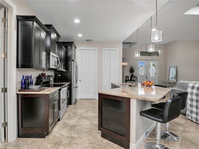 kitchen featuring french doors, sink, decorative light fixtures, a center island with sink, and stainless steel appliances