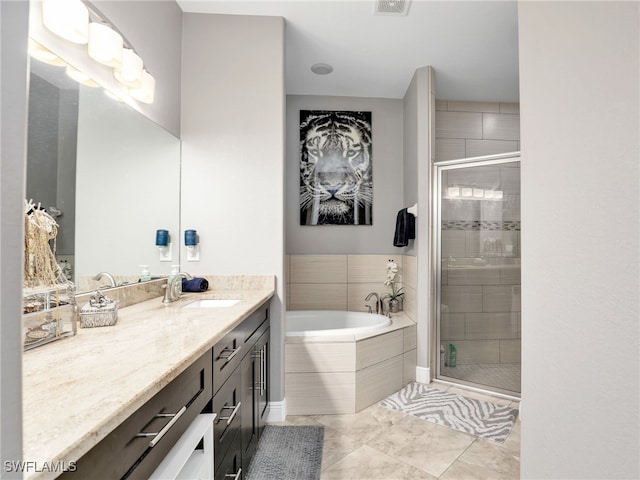 bathroom featuring independent shower and bath, tile patterned floors, and vanity