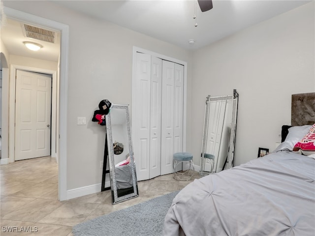 tiled bedroom featuring ceiling fan and a closet