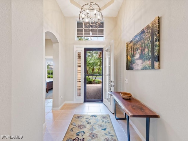 entrance foyer with light tile patterned flooring and an inviting chandelier