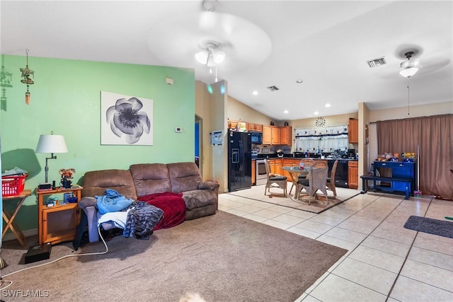 living room with ceiling fan, vaulted ceiling, and light tile patterned flooring