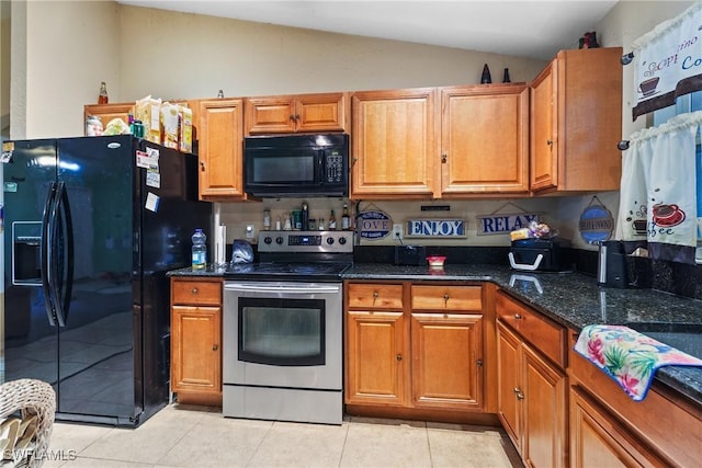 kitchen with light tile patterned flooring, black appliances, dark stone counters, and lofted ceiling